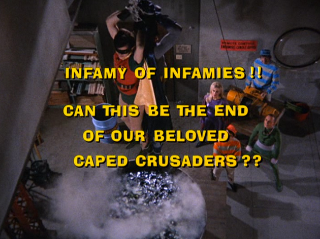 A screenshot of the Batman TV series. In the background, the Riddler dangles Batman (Adam West) and Robin (Burt Ward) over a bubbling and steaming vat. In the foreground, yellow text asks: "Infamy of Infamies!! Can this be the end of our beloved caped crusaders??"